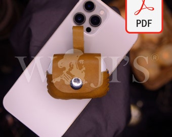 May include: A brown leather case with a strap for carrying AirPods. The case has a decorative design and a metal button. The case is sitting on top of a white iPhone.