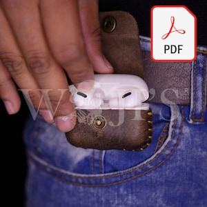 May include: A brown leather case with a stitched design and a gold button closure. The case is holding a white wireless earbud charging case.