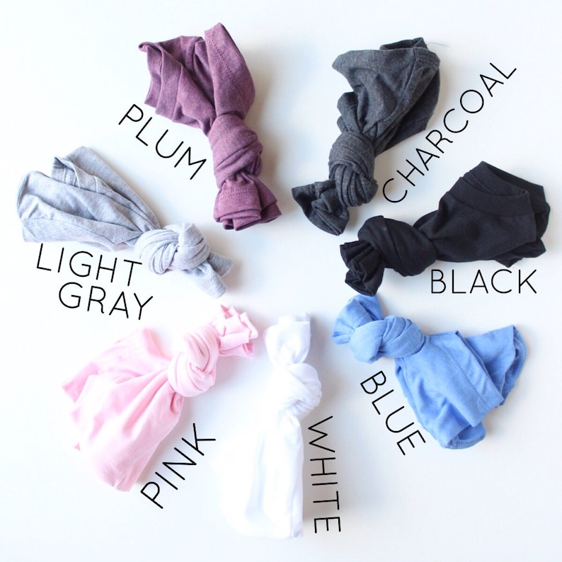 May include: Six different colors of t-shirts tied in knots. The colors are light gray, plum, charcoal, black, pink, and blue.