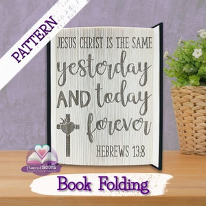 Puede incluir: Un patrón de plegado de libro con el versículo bíblico "Jesucristo es el mismo ayer, hoy y por siempre." Hebreos 13:8. El patrón incluye una cruz con un corazón.
