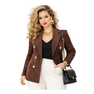 May include: A brown double-breasted blazer with gold buttons, paired with a black top and white pants. A black quilted handbag with a gold chain strap is worn over the shoulder. Gold jewelry includes a necklace and earrings.