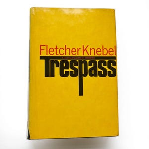 May include: A hardcover book with a bright yellow cover. The title "Trespass" is in large black block letters, with the author's name, Fletcher Knebel, in red. The book is a novel by the author of "Vanished".