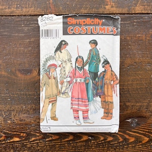 May include: A Simplicity Costumes sewing pattern envelope, number 8282, featuring illustrations of five different outfits labeled A, B, C, D, and E. The cover displays various styles of fringed garments, headpieces, and patterned clothing designs.