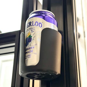 May include: A black plastic can holder with a can of sparkling water inside. The can is purple and white with the text "ERLOO" and "BLACKBERRY LEMONADE" on it.