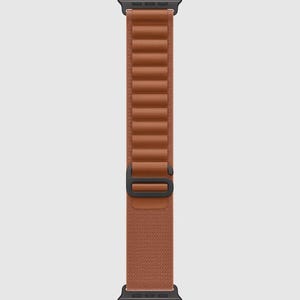 May include: A brown watch strap with a black clasp. The strap is made of a textured material and features a series of raised, rectangular segments. The watch strap is designed to attach to a smartwatch.