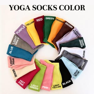 May include: A circular arrangement of ribbed yoga socks in various colors including purple, yellow, red, green, orange, brown, light purple, dark green, white, gray, light blue, black, light yellow, pink, light green, hot pink, beige, light pink, blue, and light gray.