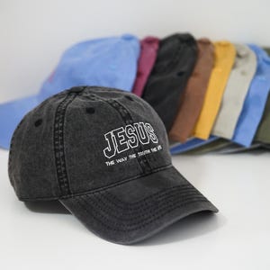 Puede incluir: Una gorra de b&eacute;isbol negra con las palabras "JESUS THE WAY THE TRUTH THE LIFE" bordadas en blanco en la parte delantera.
