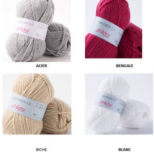 Peut inclure: Quatre pelotes de laine de diff&eacute;rentes couleurs : gris, rose, beige et blanc. Chaque pelote porte une &eacute;tiquette "PARTNER 3.5 phildar".