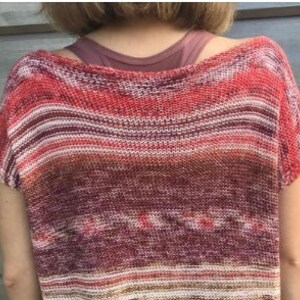 May include: A striped, short-sleeved, knit top in shades of red, orange, and brown.