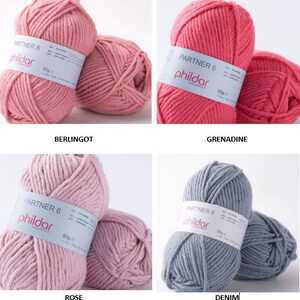 May include: Four skeins of yarn in different colors: pink, coral, light pink, and gray. Each skein has a label that says "Partner 6" and "Phildar".