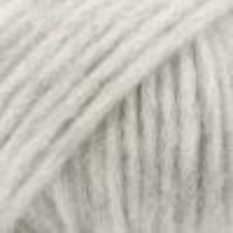 May include: A close-up view of light gray yarn, showing the twisted fiber strands arranged in parallel lines. The texture is soft and fibrous, with a consistent neutral color throughout the entire surface of the material, highlighting the individual plies.