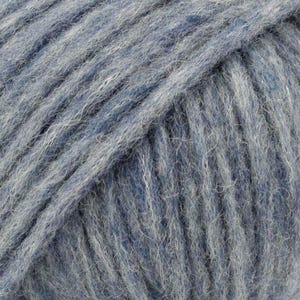 May include: A ball of yarn featuring a blend of deep navy blue and light heather gray fibers. The yarn has a fuzzy, brushed texture with visible strands twisted together, creating a multi-tonal appearance throughout the entire surface of the ball.