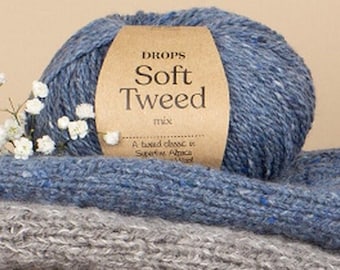 May include: A ball of blue yarn with a brown label that reads "DROPS Soft Tweed mix A tweed classic in Superfine Alpaca Wool".