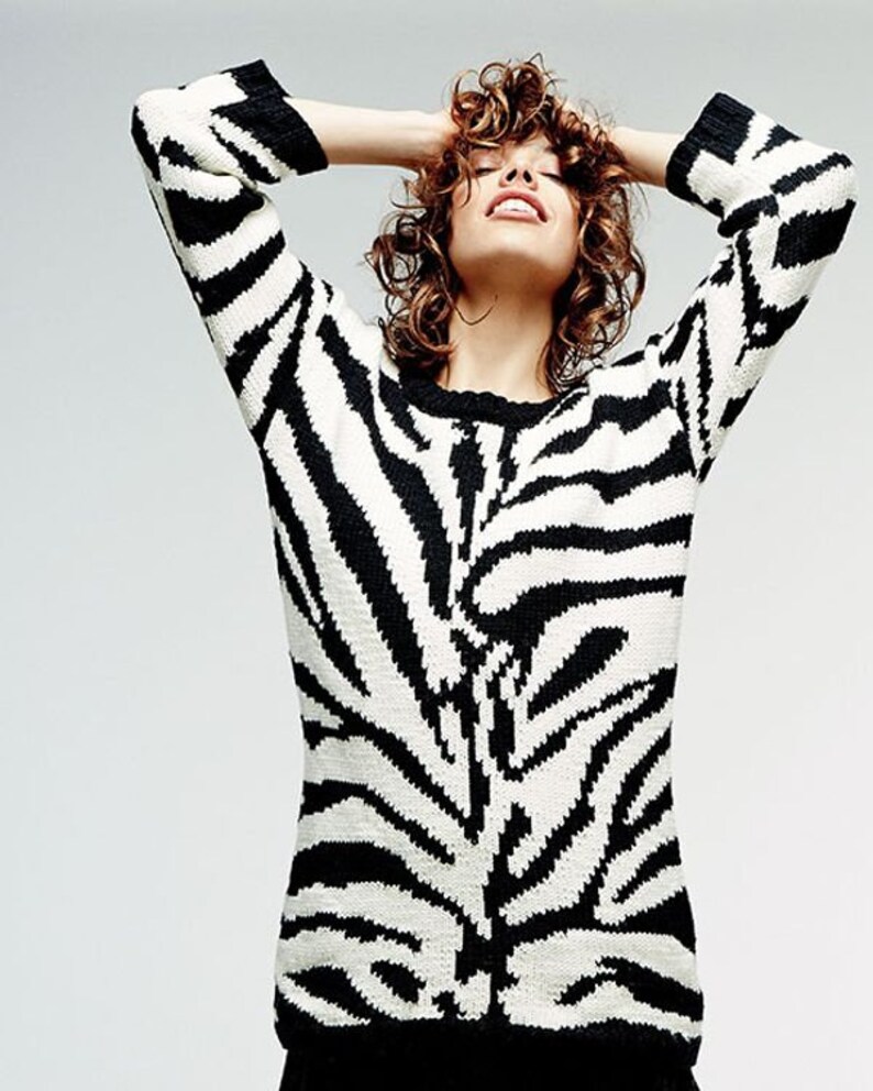 May include: A black and white zebra print sweater with long sleeves.