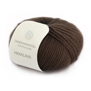 K&ouml;nnte beinhalten: Eine braune Wollkn&auml;uel mit einem wei&szlig;en Etikett, auf dem "Emmebi Manifattura Filati per Aguiglieria Himalaya" steht.