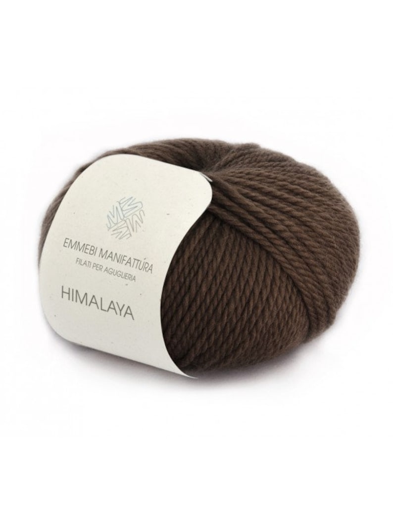 K&ouml;nnte beinhalten: Eine braune Wollkn&auml;uel mit einem wei&szlig;en Etikett, auf dem "Emmebi Manifattura Filati per Aguiglieria Himalaya" steht.
