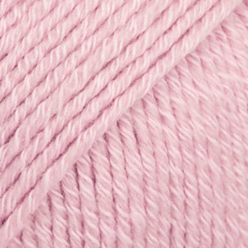 May include: A skein of pale pink yarn, a soft and fluffy texture.