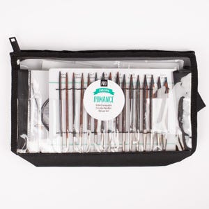 May include: A black zippered case containing a Drops Pro Romance interchangeable circular needles deluxe set. The set includes various sizes of knitting needles, with the sizes printed on the included card. The needles are silver and brown.