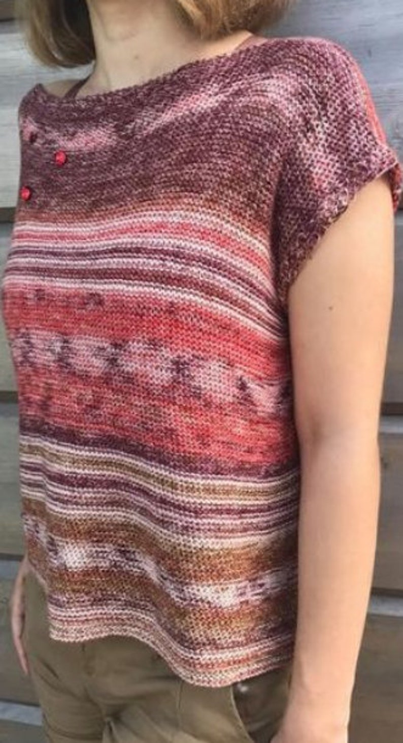 May include: A striped knit top with a boat neck and short sleeves. The top is made in a variety of shades of red, brown, and white.