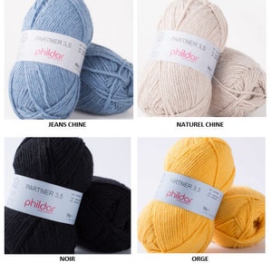 Peut inclure: Quatre pelotes de laine de couleurs diff&eacute;rentes : bleu, beige, noir et jaune. Chaque pelote porte une &eacute;tiquette "Partner 3,5 phildar".