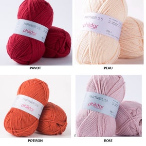 Peut inclure: Quatre pelotes de laine de couleurs diff&eacute;rentes&nbsp;: rouge, p&ecirc;che, orange et rose. Chaque pelote porte une &eacute;tiquette blanche avec le texte "PARTNER 3,5 phildar" et "50g e".