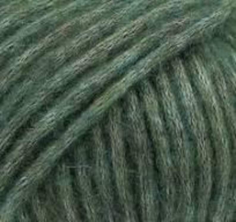 May include: A close-up view of a skein of dark sage green yarn. The fibers are tightly wound in a diagonal pattern, showcasing a soft, fuzzy texture with subtle variations in the green hue throughout the twisted strands of the yarn.