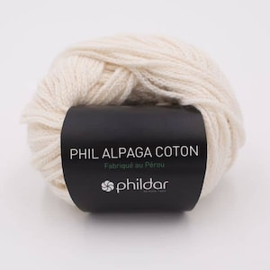Może przedstawiać: Kulka białej wł&oacute;czki z czarną etykietą z napisem "PHIL ALPAGA COTON Fabriqu&eacute; au P&eacute;rou phildar".