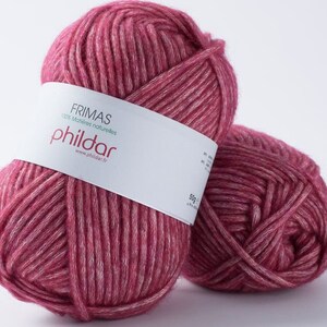 May include: Two balls of Frimas Phildar yarn in a deep rose color with white highlights. The yarn is labeled as 100% natural materials and weighs 50g. Perfect for knitting and crochet projects.