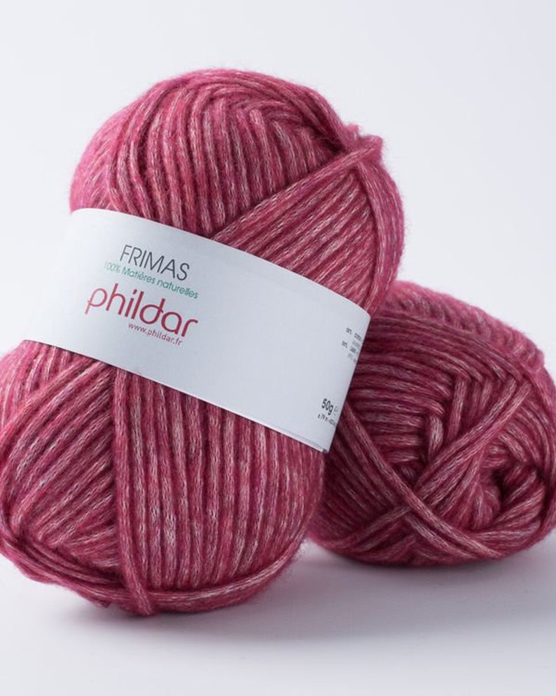May include: Two balls of Frimas Phildar yarn in a deep rose color with white highlights. The yarn is labeled as 100% natural materials and weighs 50g. Perfect for knitting and crochet projects.