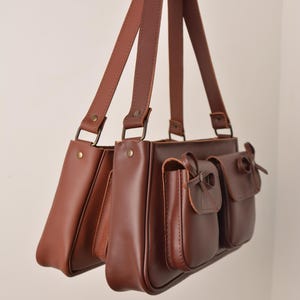 Pu&ograve; includere: Un cartello in legno rustico con la scritta "Welcome to our home" in lettere bianche. Il cartello presenta una finitura invecchiata e un design semplice e invitante, perfetto per un portico o un ingresso.