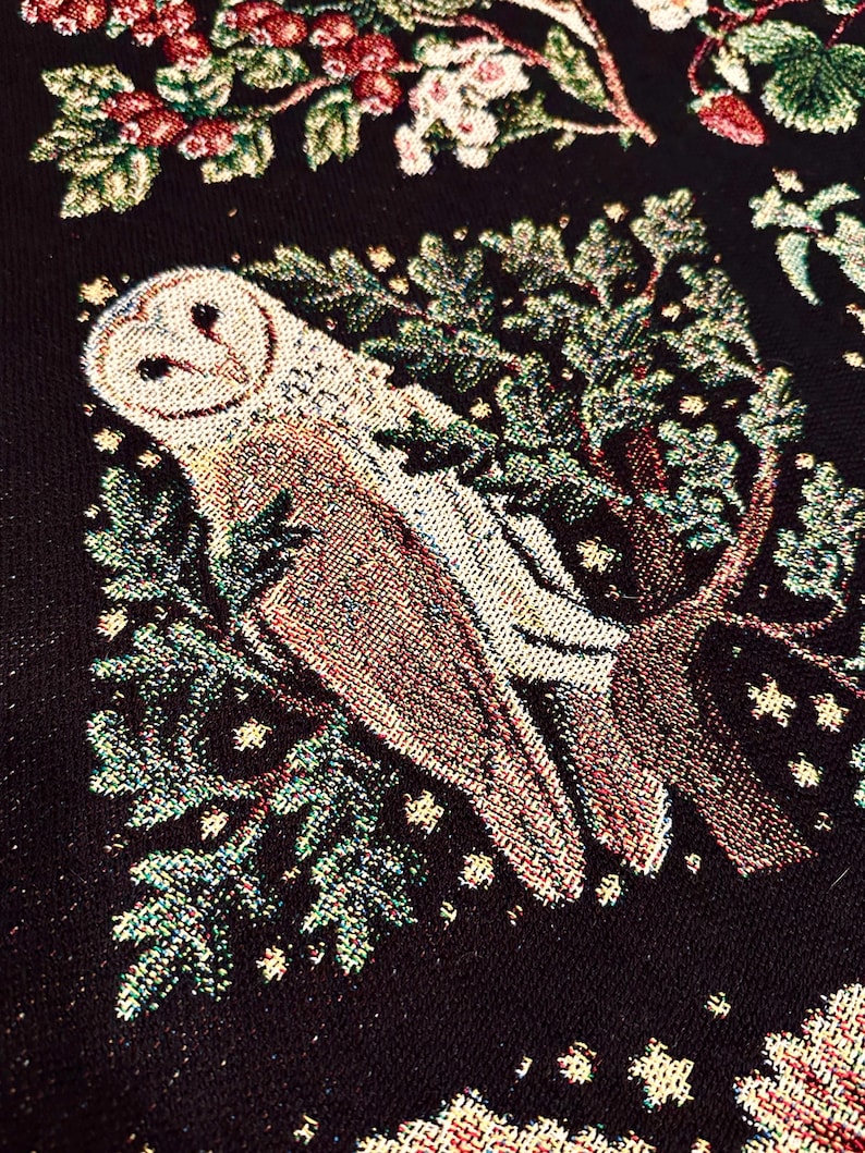 May include: A tapestry featuring a white barn owl perched on a branch with green leaves and gold stars on a black background.