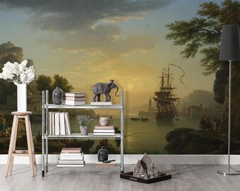 May include: A silver metal wire shelving unit holding books, a gray vase, a small potted plant, and a dark elephant figurine. The unit is placed against a wall mural depicting a harbor scene with a large sailing ship at sunset and rocky cliffs.