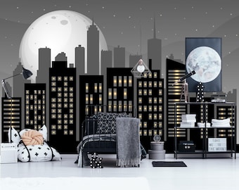 Könnte beinhalten: Ein Schlafzimmer mit einer Wandtapete, die eine nächtliche Skyline mit einem großen Mond zeigt, einem schwarzen Metallbett mit grauer Bettwäsche, einem schwarzen Regal mit Büchern, einem Teleskop, einem Schild mit Take Me To The Moon und einer Stehlampe.