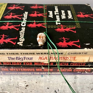 Collection of 5 Agatha Christie paperbacks tied with a vintage skull charm