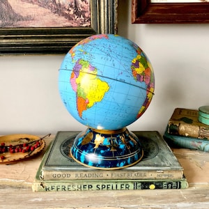 Vintage metalen spaarpot met astrologische wereldbol