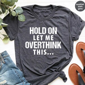 May include: Heather dark grey t-shirt with the text "Hold on let me overthink this..." printed in white.
