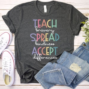 May include: A dark gray t-shirt with the text "TEACH bravery SPREAD kindness ACCEPT differences" in rainbow colors.