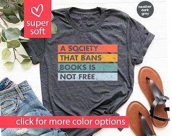 May include: A heather dark grey t-shirt with a vintage-style graphic that reads "A society that bans books is not free".