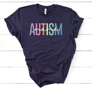 May include: A navy blue t-shirt with the text "AUTISM mama" in rainbow colors.