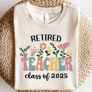 May include: A white t-shirt with the text "Retired Teacher class of 2025" in black. The word "Teacher" is in colorful, stylized letters with flowers around it.