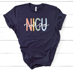 May include: A navy blue t-shirt with the text "NICU nurse" in rainbow colors. The text is in a stylized font.