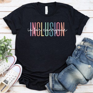 May include: A black t-shirt with the text "Inclusion is for everyone" in rainbow colors.