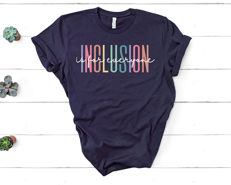 May include: A navy blue t-shirt with the text "Inclusion is for everyone" in rainbow colors.