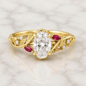 Peut inclure: Une bague en or jaune avec une pierre précieuse blanche centrale de taille ovale fixée par des griffes. L'anneau est orné de feuilles en or sculptées, de deux rubis rouges taille marquise et de quatre petits diamants blancs ronds.