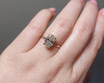 May include: A gold engagement ring with an oval-shaped diamond.