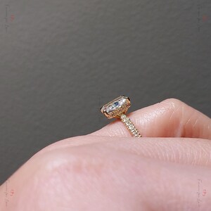 May include: A gold engagement ring with a large, clear, cushion-cut diamond center stone and a pave diamond band.