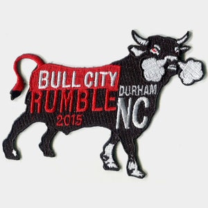 May include: Black embroidered patch of a bull with the text "Bull City Rumble NC 2015" and "Durham" above the text "NC".
