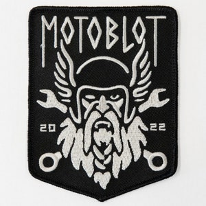 May include: Black and white embroidered patch with a Viking-like figure wearing a helmet and holding two wrenches. The text "MOTOBLOT" is above the figure and the numbers "20" and "22" are below the figure.