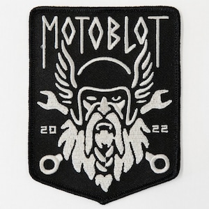 May include: Black and white embroidered patch with a Viking-like figure wearing a helmet and holding two wrenches. The text "MOTOBLOT" is above the figure and the numbers "20" and "22" are below the figure.