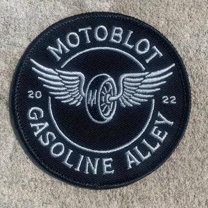 May include: Black and white embroidered patch with the text "Motoblott Gasoline Alley 20 22" and a stylised image of a winged tyre.